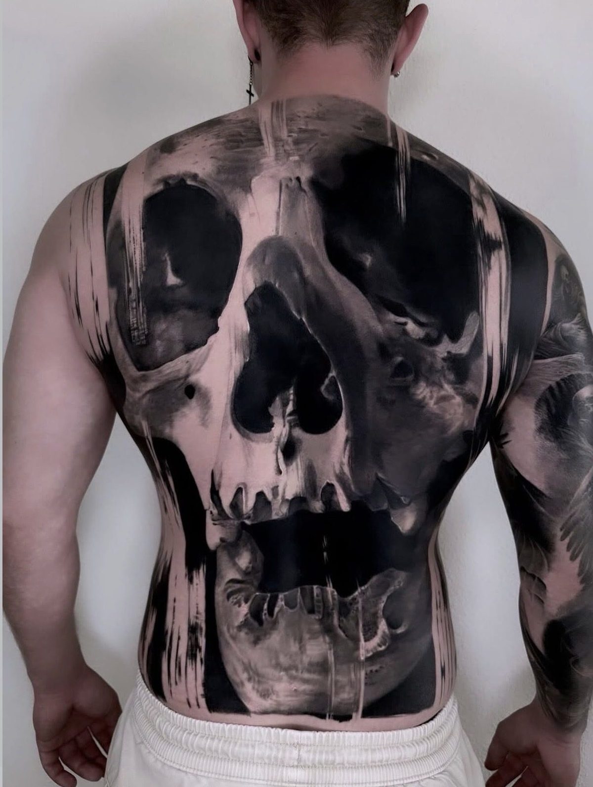 Large skull covering the full back, black and grey realism tattoo by Ruby Ink